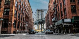 Street view with bridge between two brick buildings