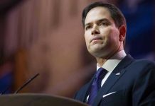 Man in suit speaking at podium.