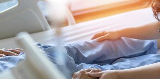 Hospital patient holding visitors hand reassuringly