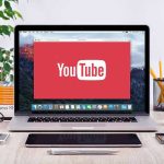 YouTube logo on a laptop screen on desk
