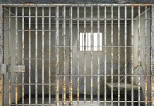Empty rusty prison cell with a small window.