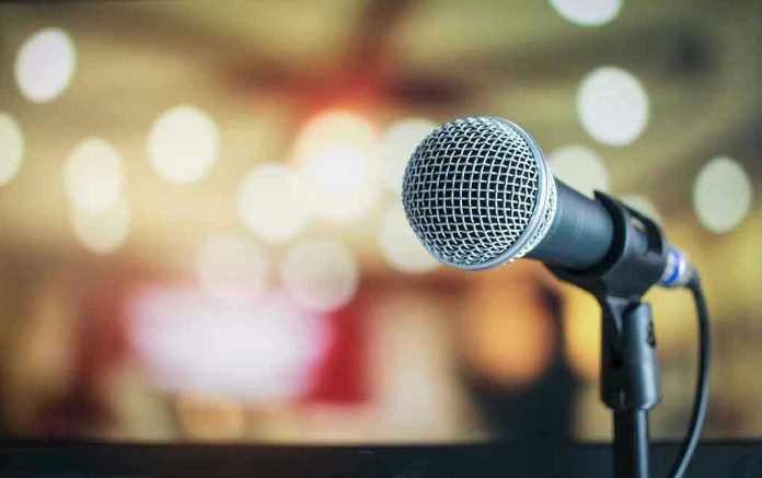 676019521 Microphone with blurred lights in the background