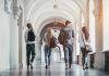 Four students walking in a corridor together.