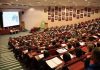 Students seated in a lecture hall listening to a presentation