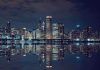 Nighttime view of a city skyline with reflections on water