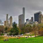 People relaxing in a park, city skyline background