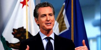Newsom BETRAYS Citizens — Shields Big Tech Man speaking with flags in the background
