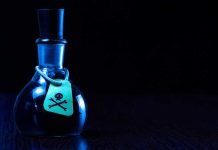 Dark bottle with skull and crossbones label on table