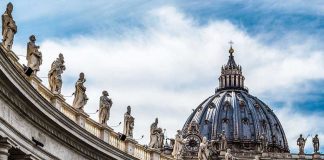 St Peters Basilica dome with statues and clouds