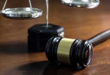 Gavel and scales of justice on wooden table