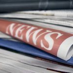 Stack of newspapers with NEWS headline visible