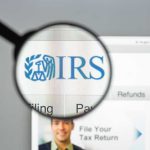 Audit Storm Hits Progressive Groups—IRS Overdrive Magnifying glass over IRS website.