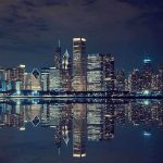 Trump’s Bold Insurrection Act Move—Chicago Shocked Nighttime view of a city skyline with reflections on water