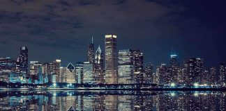 Trump’s Bold Insurrection Act Move—Chicago Shocked Nighttime view of a city skyline with reflections on water