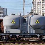 Private Firms Get Plutonium Access – Outrage Erupts A railway tank car with a nuclear warning symbol parked on tracks near urban buildings