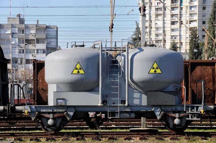 shutterstock_72241936.jpg A railway tank car with a nuclear warning symbol parked on tracks near urban buildings