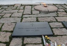 Memorial site for John F Kennedy featuring a grave marker and an eternal flame