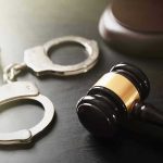 Court Denies Rich Teen’s Escape from Murder Trial Handcuffs and judges gavel on the table.