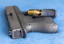 Armed Intruder Down—Police Storm Home Handgun on blue fabric with visible bullet cartridge