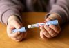 Lawsuits Explode Over Dangerous Ozempic Side Effects Hands holding an Ozempic injection pen.