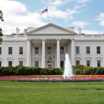 The White House surrounded by colorful flower beds and a fountain