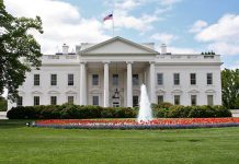 Newsom’s White House Plot EXPOSED Despite Opposition The White House surrounded by colorful flower beds and a fountain