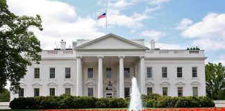 Newsom’s White House Plot EXPOSED Despite Opposition The White House surrounded by colorful flower beds and a fountain