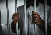 Child Killer WALKS FREE After Law Overrules Parole Person holding jail cell bars tightly.