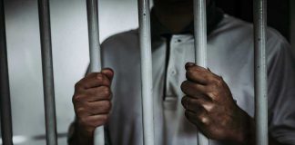 Child Killer WALKS FREE After Law Overrules Parole Person holding jail cell bars tightly.