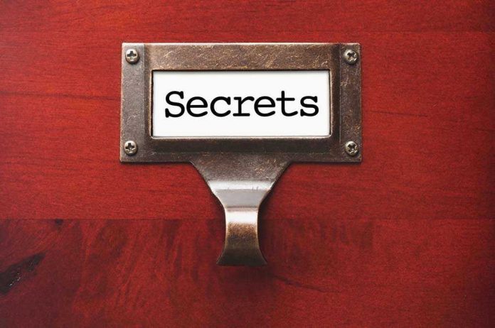 106336844 Metal label holder saying Secrets on wood background