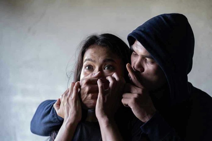 Man holding womans mouth, gesturing silence.