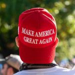 MAGA Infighting Breaks Into the Open Person wearing a red Make America Great Again hat.