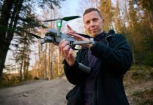Drone Steak Drop EXPOSES Shocking Prison Chaos Person holding a drone in a forest.