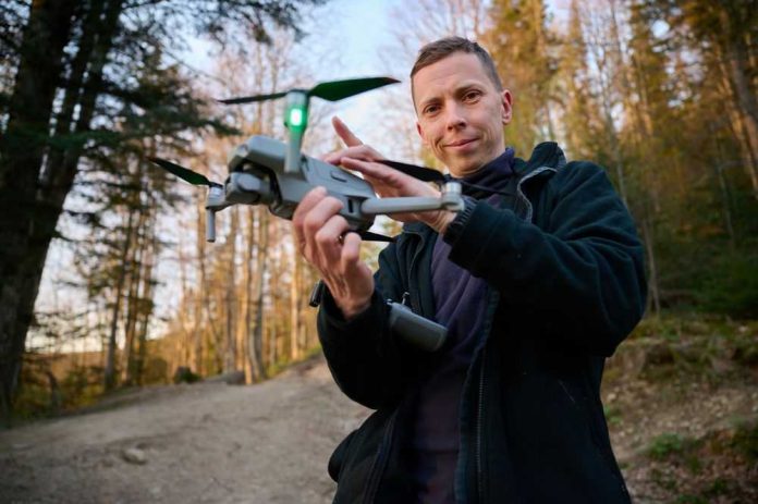 2479750341 Person holding a drone in a forest.