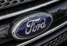 $19.5B EV Gamble BLOWS UP Ford logo on car grille close-up.
