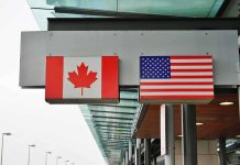 Canadian and American flags displayed at a border crossing