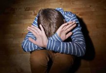 System Failure Exposed in Child Horror Case A child sitting on the floor with their hands covering their face, expressing distress