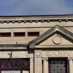 Stone building facade with bank sign and columns