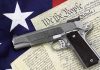 Gun Rights Face Defining Supreme Court Test Gun on U.S. Constitution and flag.