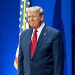 $10B FROZEN By Trump Stuns Democrats Man in suit next to American flag.