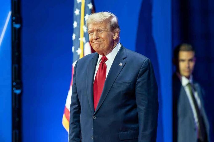 2429741175 Man in suit next to American flag.