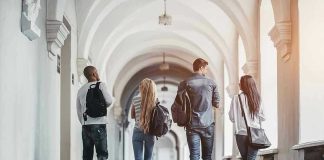 Four students walking in a corridor together.