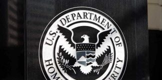 U.S. Department of Homeland Security emblem on wall.