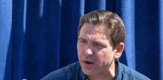 Man in Desantis for President shirt speaking.