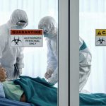 Ebola Emergency? Truth Behind WHO’s Alarming Call Healthcare workers in protective gear in quarantine room.