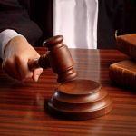DOJ Rocked by Mystery Billionaire’s Secret Funding Judges gavel on desk with books.