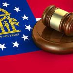 Georgia flag and judges gavel on wooden base.