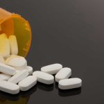 Spilled prescription bottle with white pills.