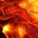 Burning U.S. dollar bills surrounded by flames
