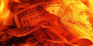 Burning U.S. dollar bills surrounded by flames